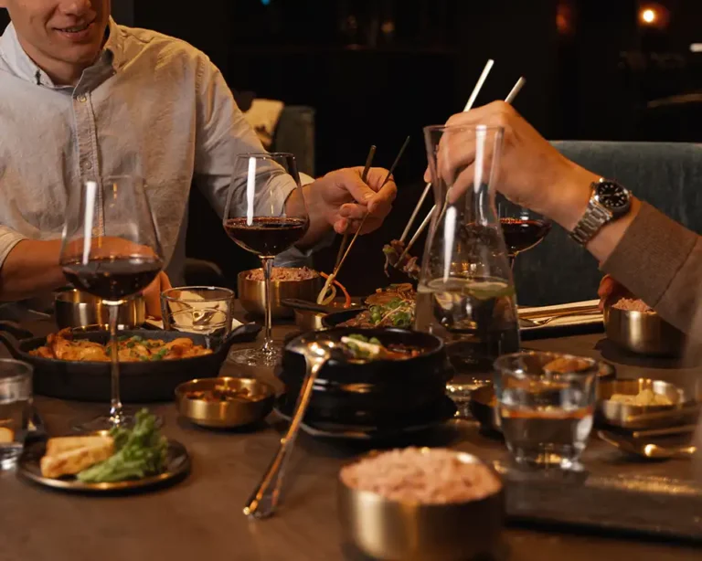 guests dining at komo korean steakhouse & bar enjoying korean bbq with food and drinks at the table. large group reservations at komo