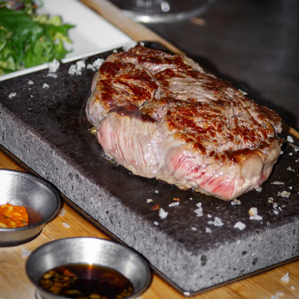 Ribeye steak on a volcanic hot stone served at KOMO korean steakhouse gothenburg